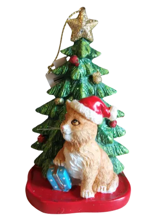 Brown Cat Sitting By Christmas Tree Wearing A Red Santa Hat Ornament